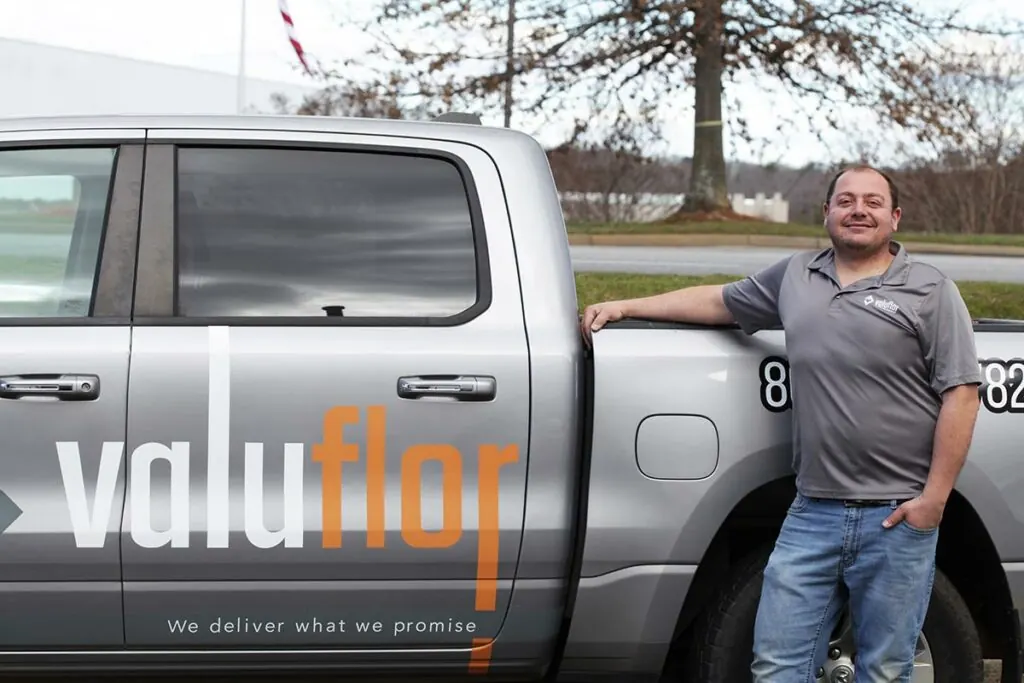 A ValuFlor team member leaning on a company truck